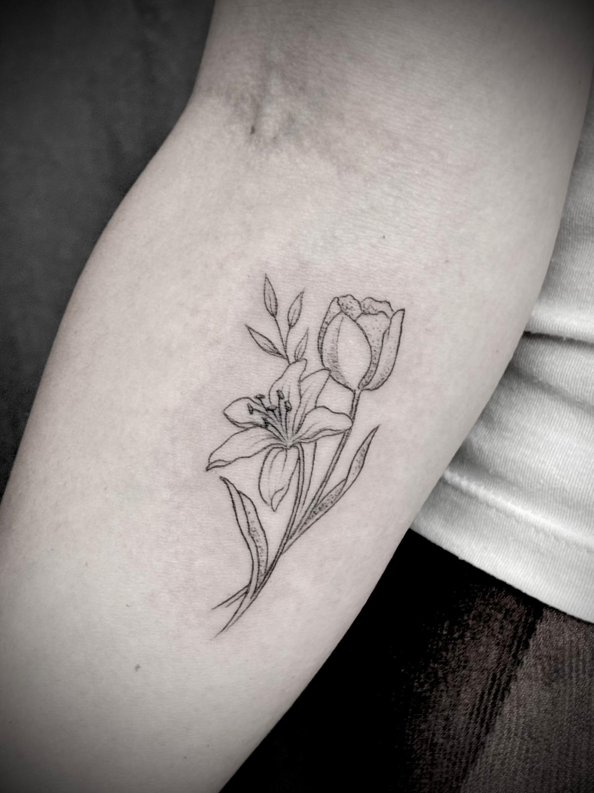 Tatuagem fine line de lírio e tulipa no braço por Heltattoo