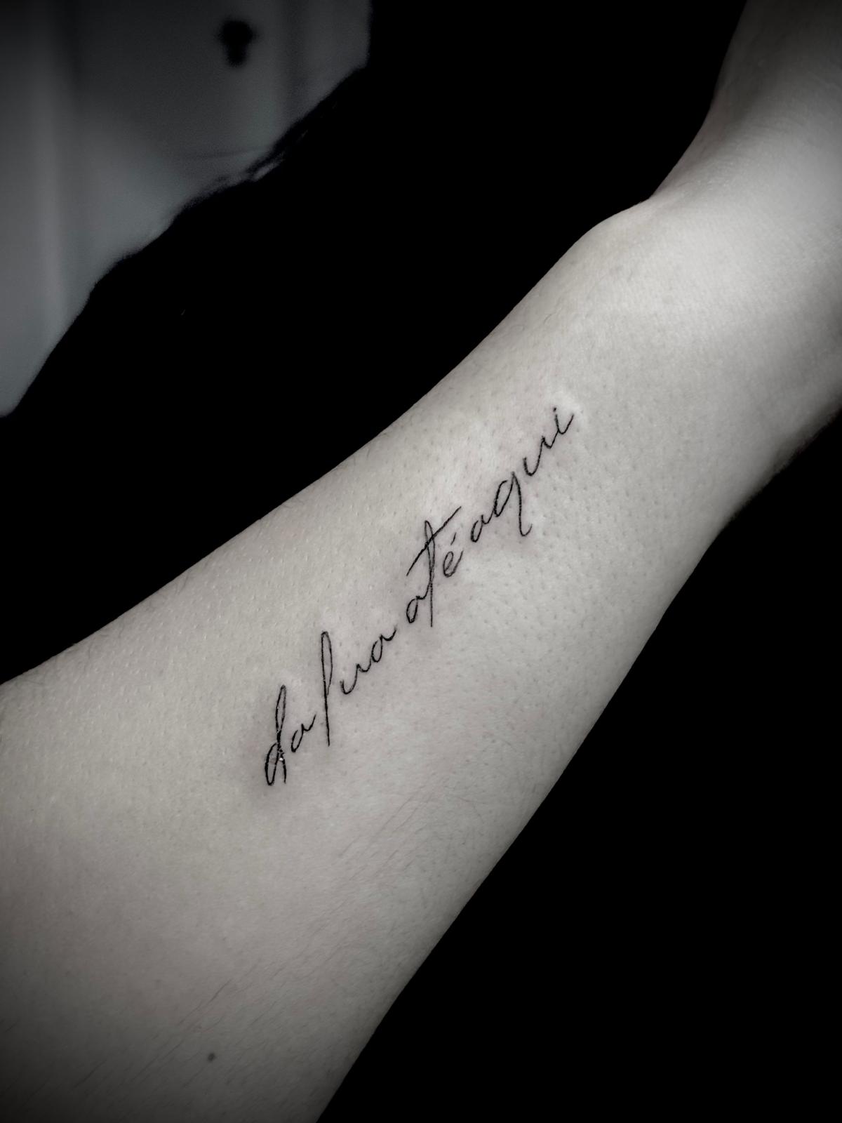 Tatuagem lettering 'da Pua até aqui' no antebraço por Heltattoo